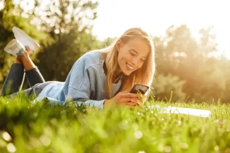 girl-sitting-on-grass-with-phone